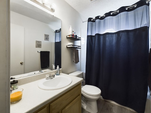 bathroom featuring toilet, wood-type flooring, a textured ceiling, vanity, and curtained shower