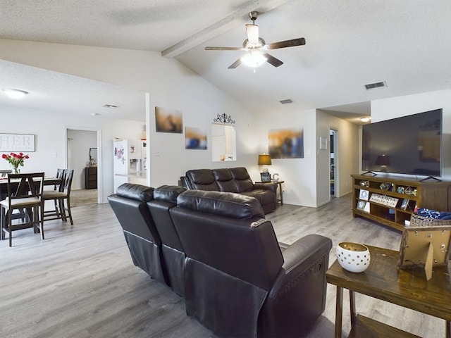 living room with ceiling fan, light hardwood / wood-style flooring, lofted ceiling with beams, and a textured ceiling