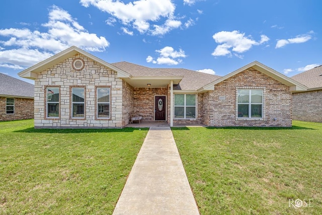 4113 Huntleigh Dr, San Angelo, TX 76904 - view of front of house featuring a front yard, brick siding, roof with shingles, and stone siding