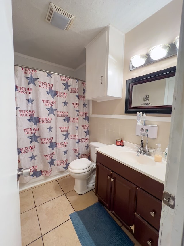 417 E 47th St, San Angelo, TX 76903 - full bath featuring vanity, tile patterned floors, a shower with shower curtain, tile walls, and wainscoting