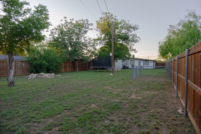 417 E 47th St, San Angelo, TX 76903 - fenced backyard with a trampoline