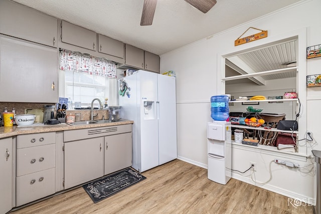 2822 N St, San Angelo, TX 76901 - kitchen with white fridge with ice dispenser, gray cabinets, light wood-type flooring, ceiling fan, and light countertops