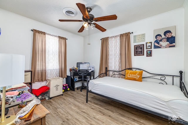 2822 N St, San Angelo, TX 76901 - bedroom featuring crown molding, light wood finished floors, ceiling fan, and a textured ceiling