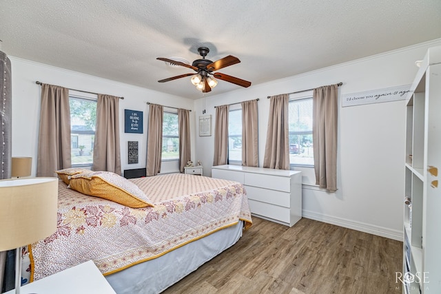 2822 N St, San Angelo, TX 76901 - bedroom featuring wood finished floors, a textured ceiling, ornamental molding, and a ceiling fan