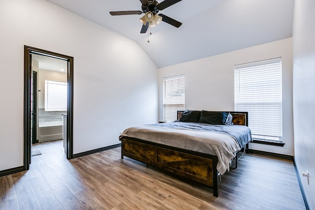 bedroom with lofted ceiling, ceiling fan, ensuite bath, wood finished floors, and baseboards