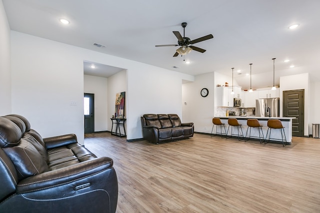 living area with ceiling fan, recessed lighting, visible vents, baseboards, and light wood finished floors