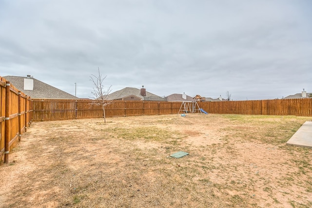 view of yard featuring a playground and a fenced backyard