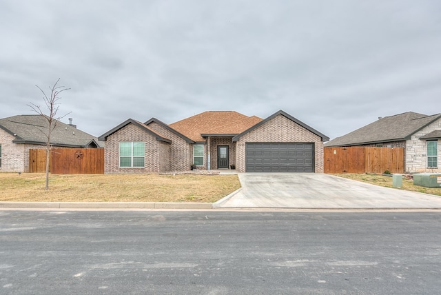 view of front of property with concrete driveway, brick siding, an attached garage, and fence