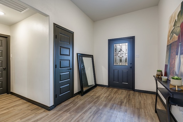 entrance foyer with wood finished floors, visible vents, and baseboards