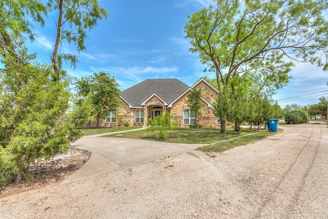 view of front of home with brick siding, a front lawn, and stone siding