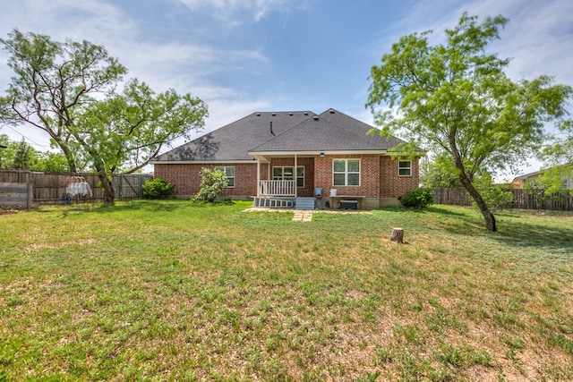 back of property featuring a lawn, brick siding, and a fenced backyard