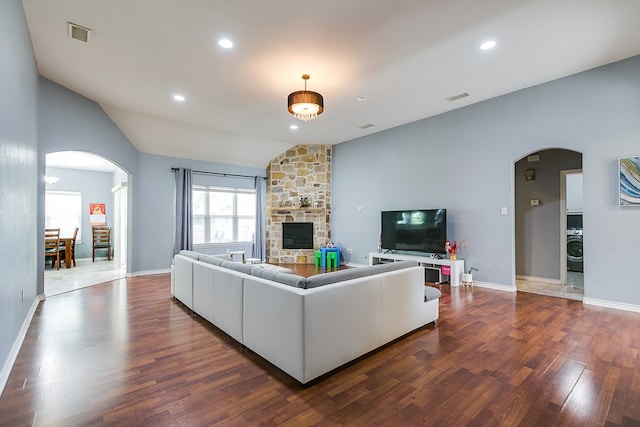 living area featuring visible vents, arched walkways, dark wood-type flooring, and lofted ceiling