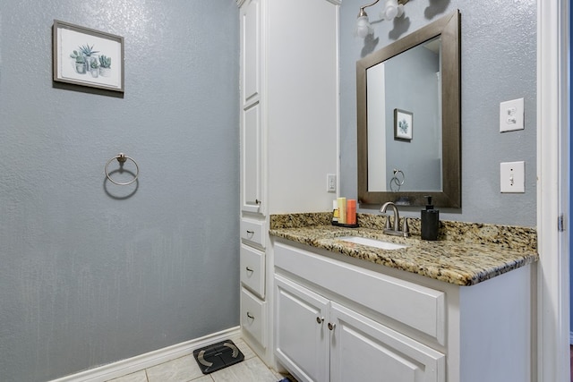 bathroom featuring vanity, baseboards, and tile patterned flooring