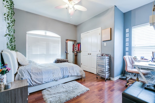 bedroom with a ceiling fan, baseboards, wood finished floors, and a closet