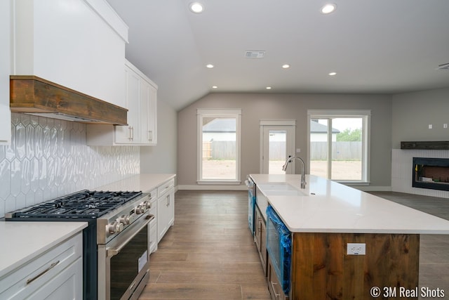 5201 Royal Oak Dr, San Angelo, TX 76904 - kitchen featuring stainless steel range, white cabinets, a fireplace, recessed lighting, and backsplash