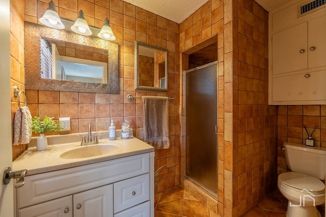 bathroom with a shower stall, visible vents, tile walls, and tile patterned floors