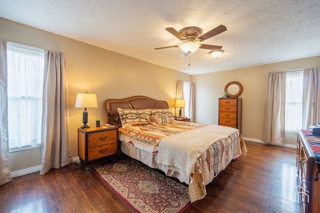 bedroom with dark wood-style flooring, multiple windows, and baseboards