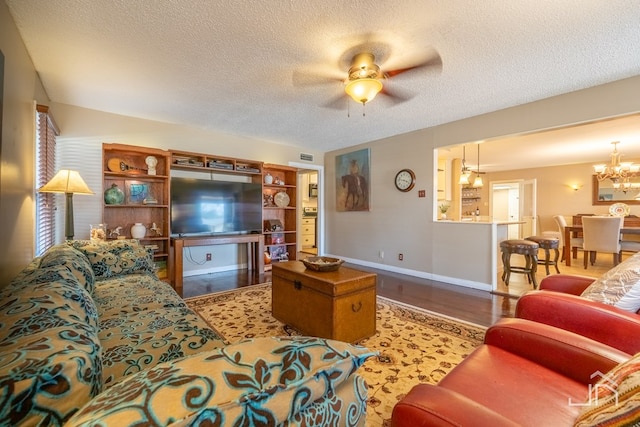 living area featuring a textured ceiling, baseboards, and wood finished floors