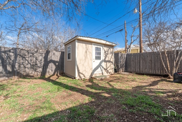 view of yard featuring a shed, an outdoor structure, and a fenced backyard