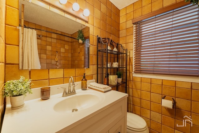 full bath featuring toilet, curtained shower, vanity, and tile walls