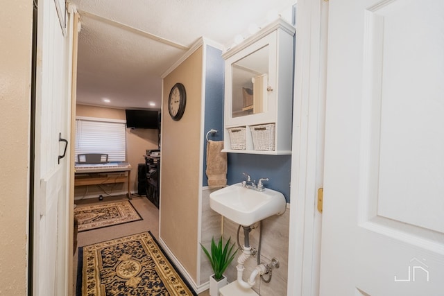 bathroom with a textured ceiling and a sink