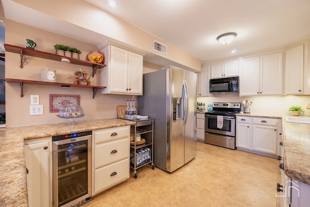 kitchen with beverage cooler, visible vents, stainless steel appliances, light countertops, and a sink