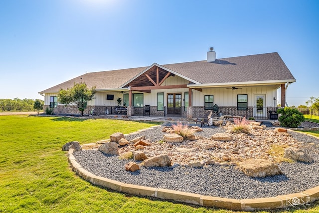 back of property featuring a yard and ceiling fan