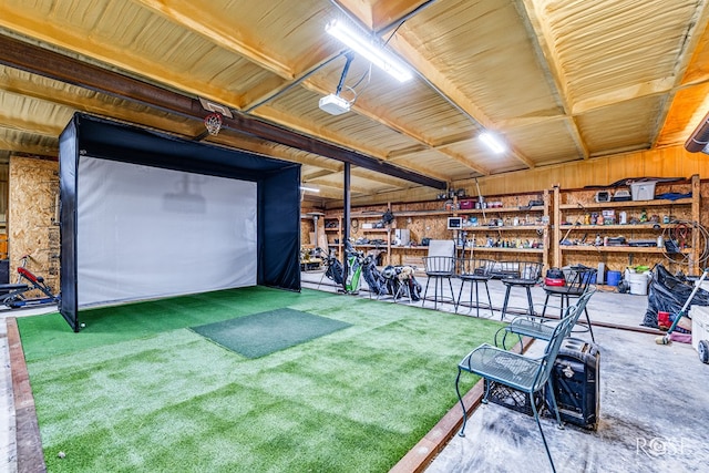 recreation room featuring golf simulator, carpet flooring, and wood walls