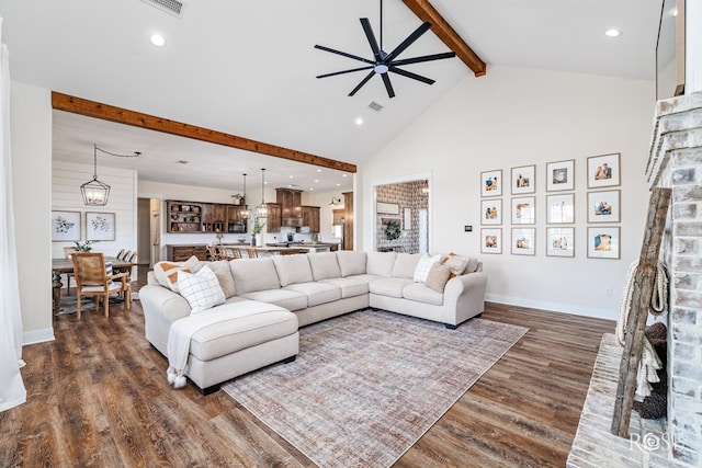 living room with ceiling fan with notable chandelier, high vaulted ceiling, a fireplace, dark hardwood / wood-style flooring, and beam ceiling