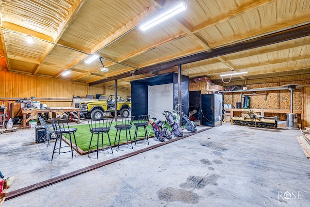 garage with wooden walls and a workshop area