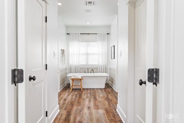 bathroom with hardwood / wood-style flooring and a washtub