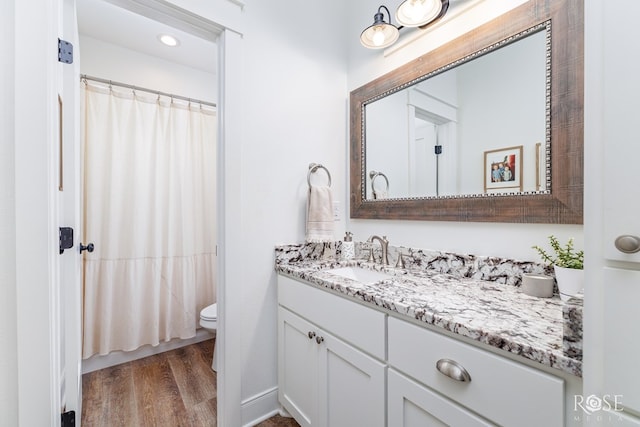 bathroom with vanity, hardwood / wood-style floors, and toilet