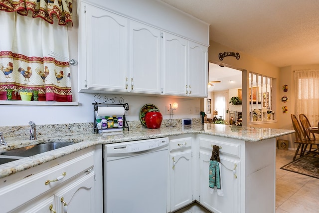 kitchen featuring sink, light stone counters, dishwasher, kitchen peninsula, and white cabinets