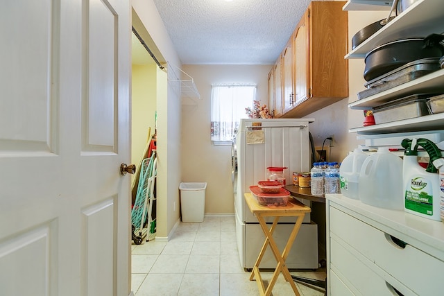 laundry area with light tile patterned floors and a textured ceiling