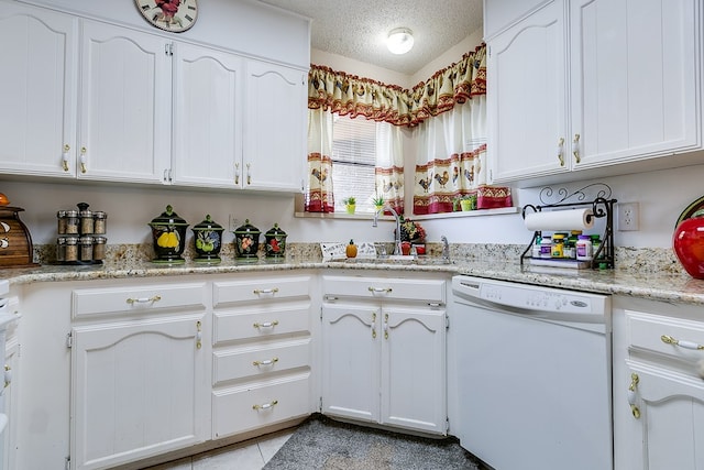 kitchen with sink, dishwasher, white cabinetry, light stone countertops, and a textured ceiling