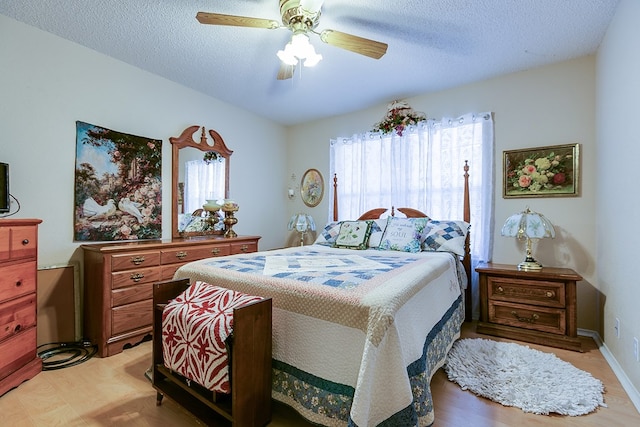 bedroom with light wood-type flooring, a textured ceiling, and ceiling fan