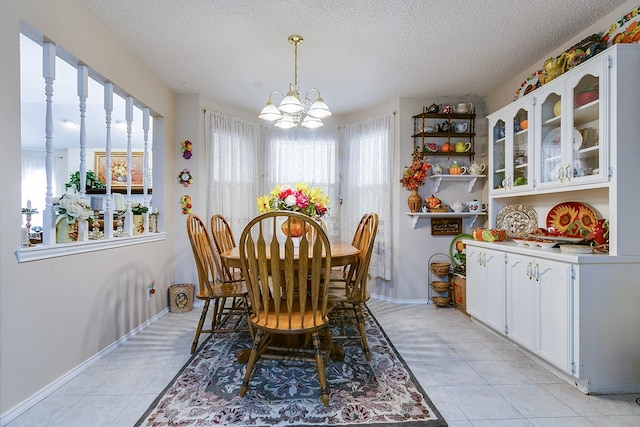 tiled dining room with a textured ceiling and a notable chandelier