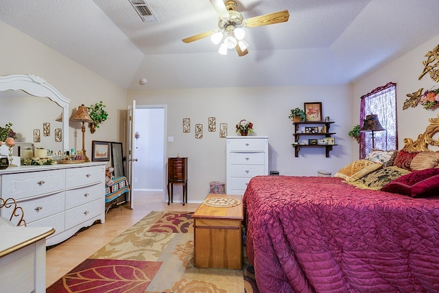 bedroom with ceiling fan, a tray ceiling, vaulted ceiling, and light hardwood / wood-style flooring