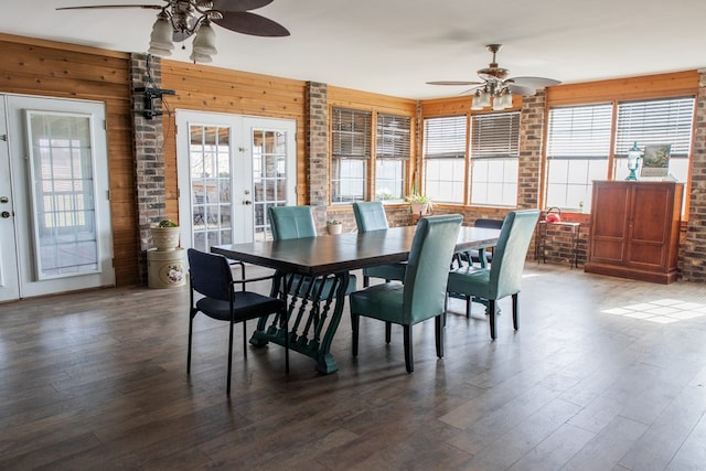 dining room featuring ceiling fan, wood walls, dark hardwood / wood-style flooring, and french doors