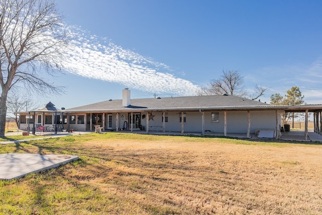 back of house with a lawn and a patio