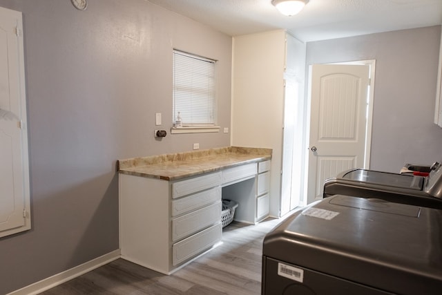 clothes washing area with washer / clothes dryer and light hardwood / wood-style floors