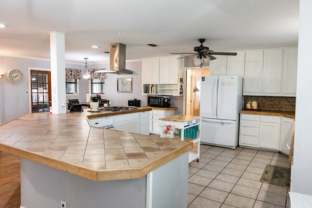 kitchen featuring hanging light fixtures, island range hood, white cabinets, and white fridge