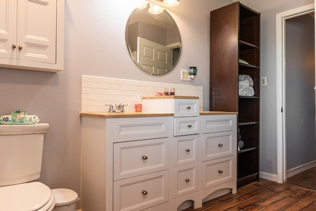 bathroom with vanity, decorative backsplash, and toilet