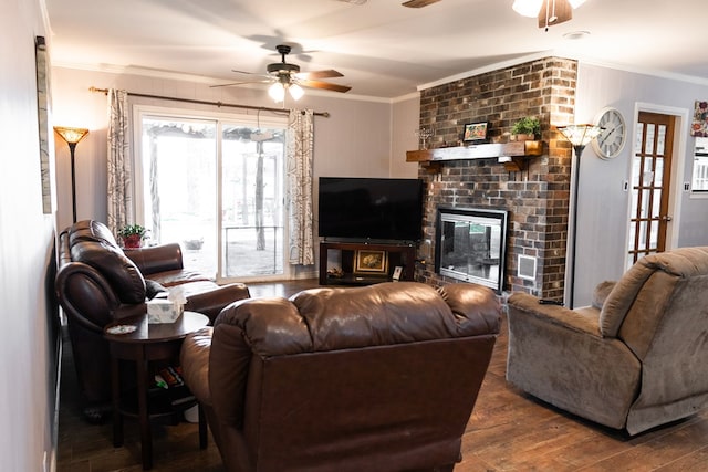 living room with crown molding, ceiling fan, dark hardwood / wood-style floors, and a fireplace