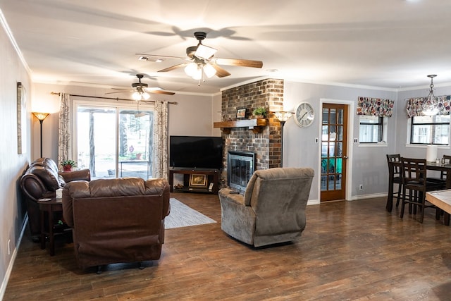 living room with crown molding, dark hardwood / wood-style flooring, ceiling fan, and a fireplace