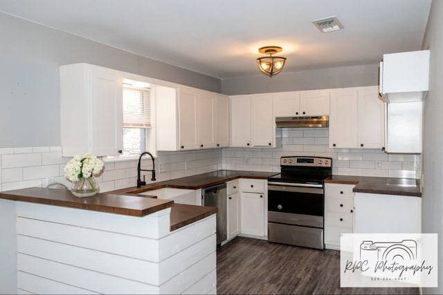 kitchen with sink, appliances with stainless steel finishes, white cabinetry, dark hardwood / wood-style flooring, and decorative backsplash