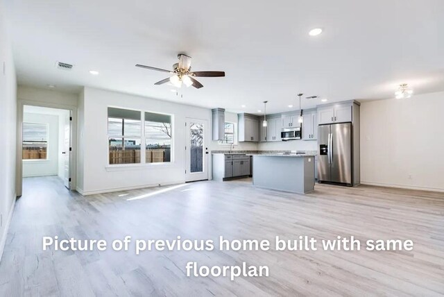 314 W 12th St, San Angelo, TX 76903 - kitchen featuring stainless steel appliances, gray cabinets, open floor plan, recessed lighting, and a center island
