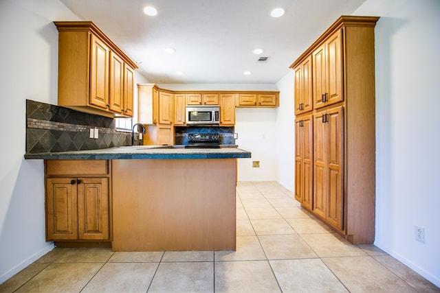 1617 Idaho Ave, San Angelo, TX 76904 - kitchen with stainless steel microwave, black range, a peninsula, backsplash, and recessed lighting