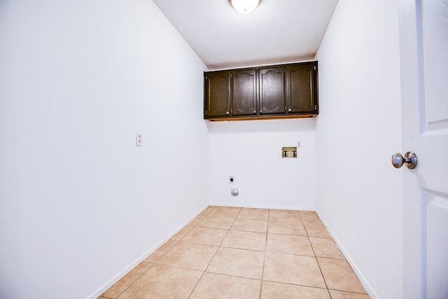 1617 Idaho Ave, San Angelo, TX 76904 - laundry room with cabinet space, washer hookup, electric dryer hookup, and light tile patterned floors