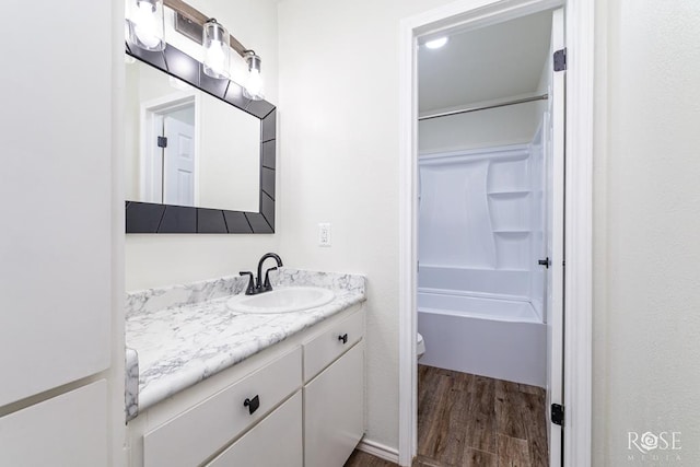 bathroom with vanity, hardwood / wood-style flooring, a shower, and toilet